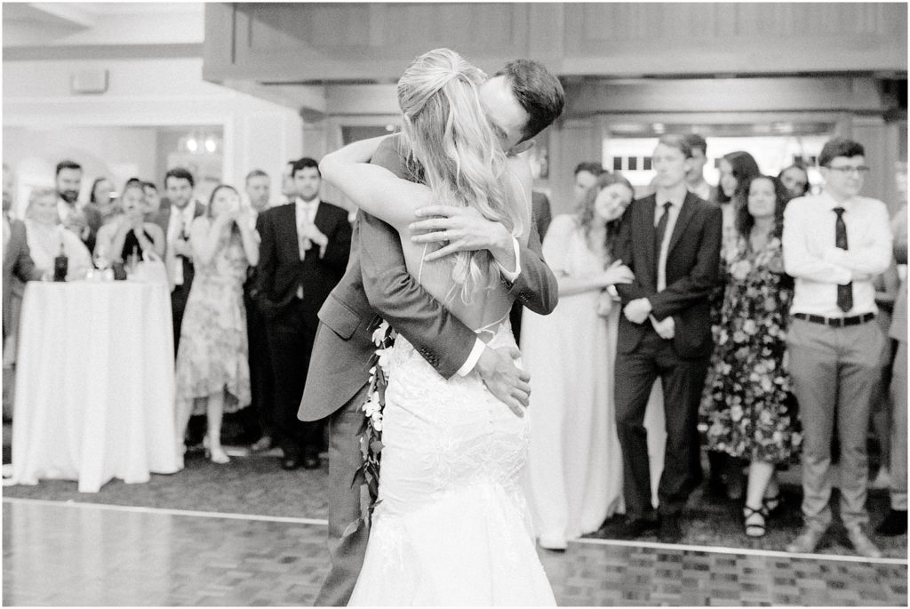 bride and groom embrace during first dance at wedding reception