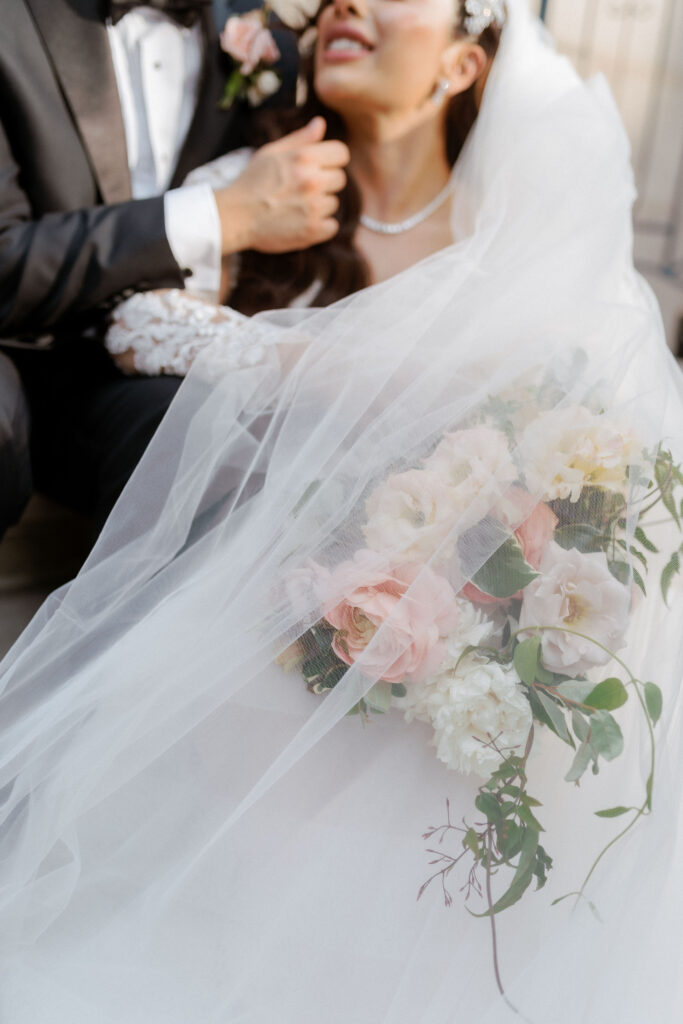 Close up of groom embracing bride while holding bouquet