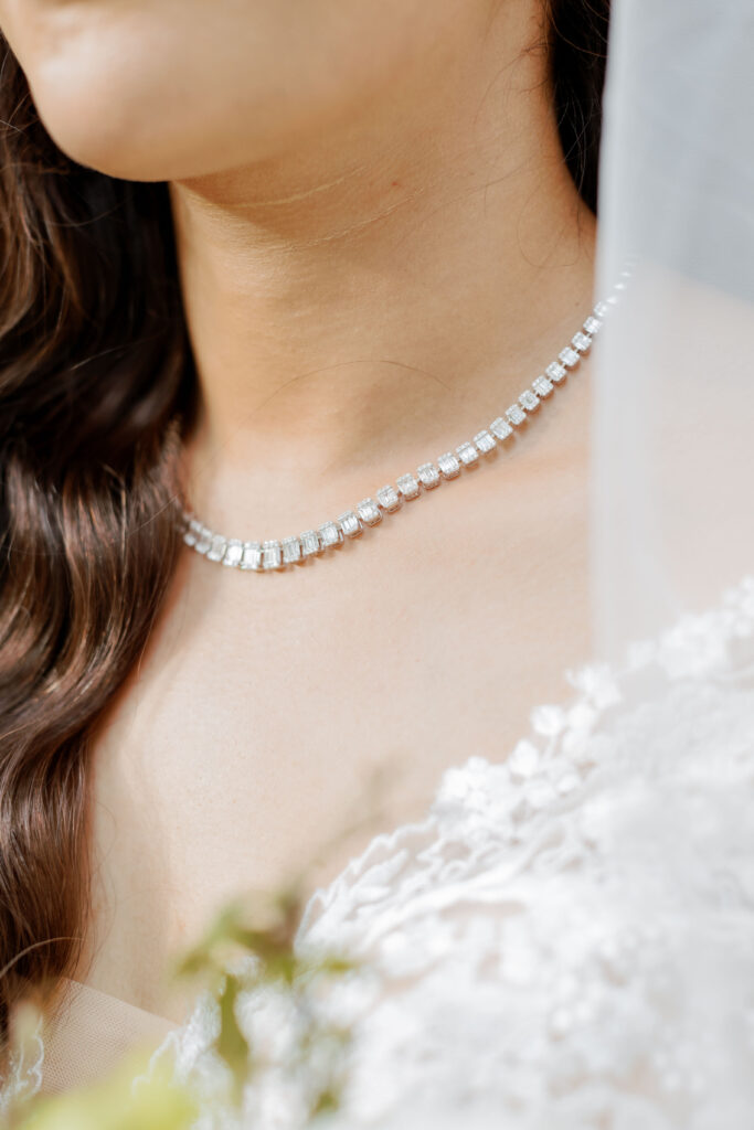 Close up of bride showcasing her diamond necklace