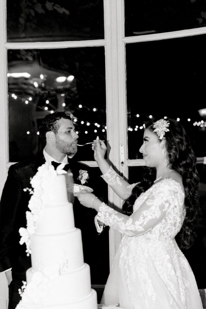 Black and white photo of bride and groom cake cutting